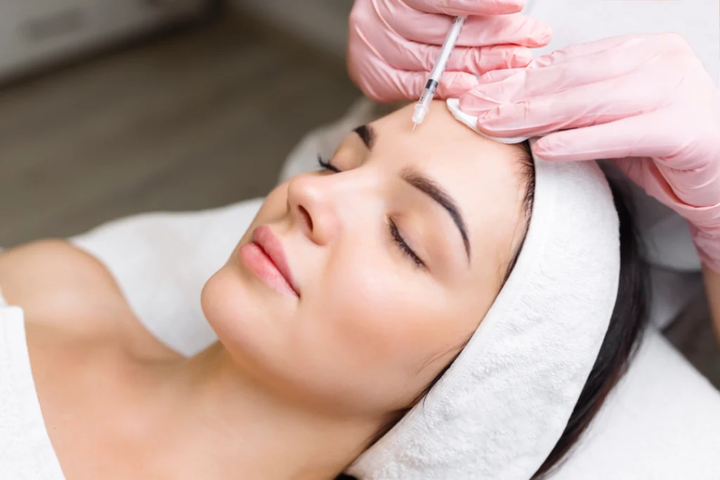 A professional administering Jeuveau injections for wrinkle reduction.